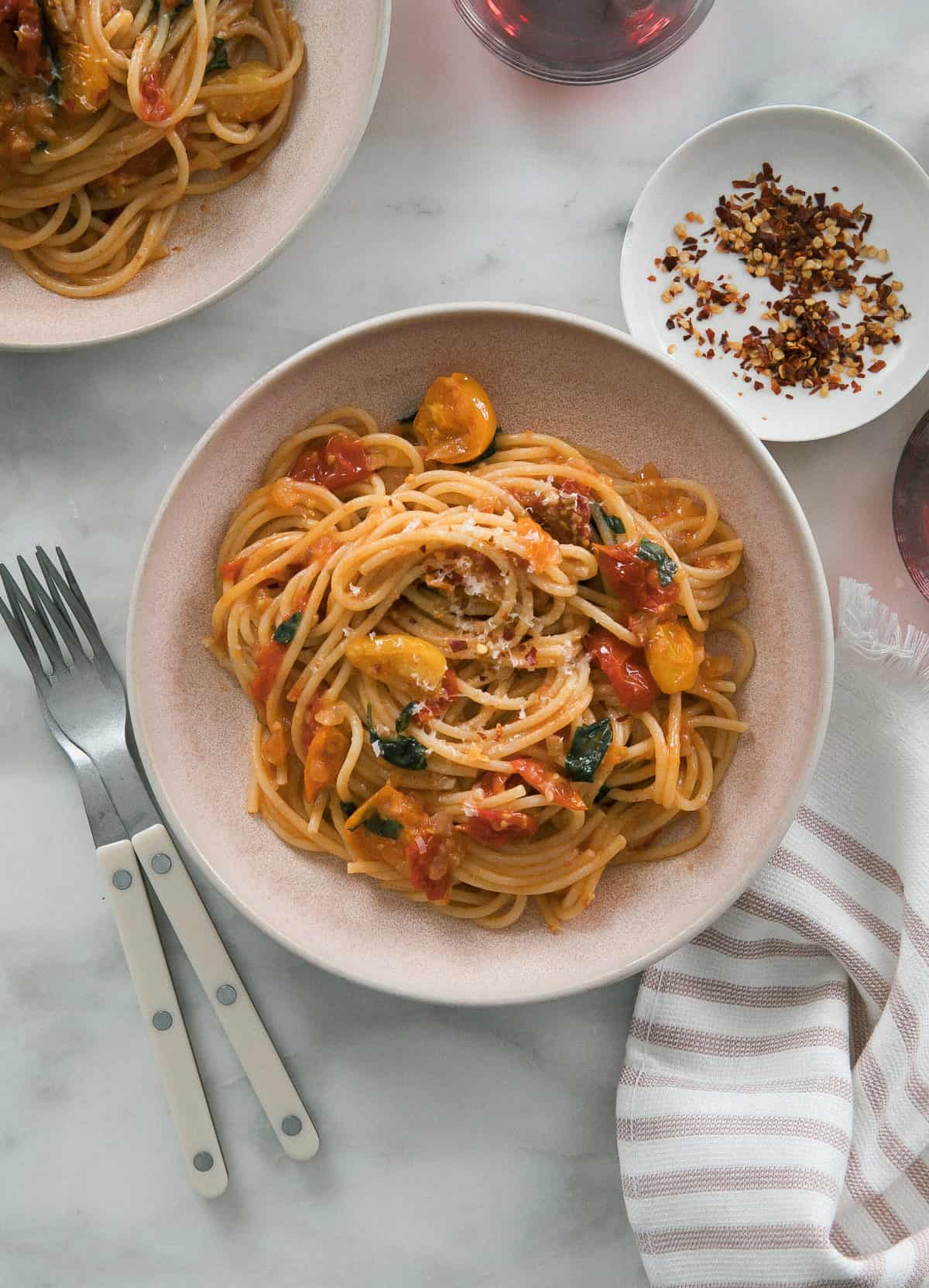 Cherry Tomato Pasta in a bowl with fork and crushed red pepper. 