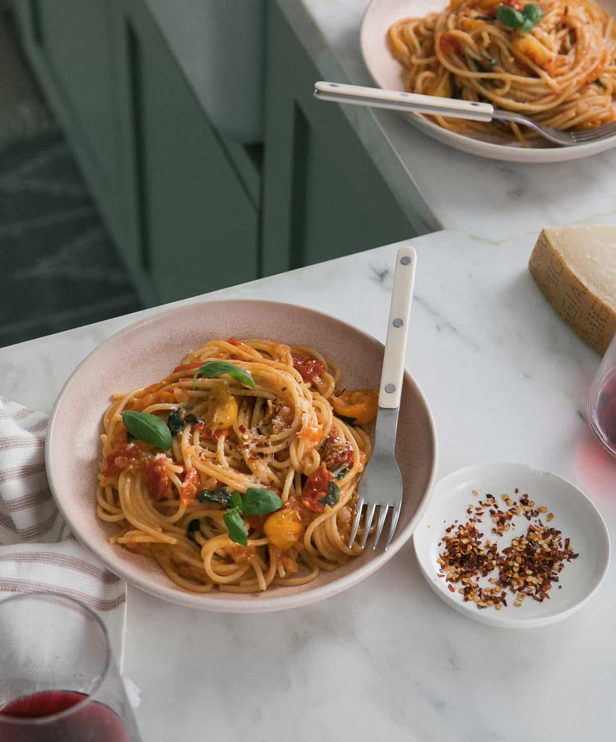 Cherry Tomato Pasta in a bowl with fork and crushed red pepper. 