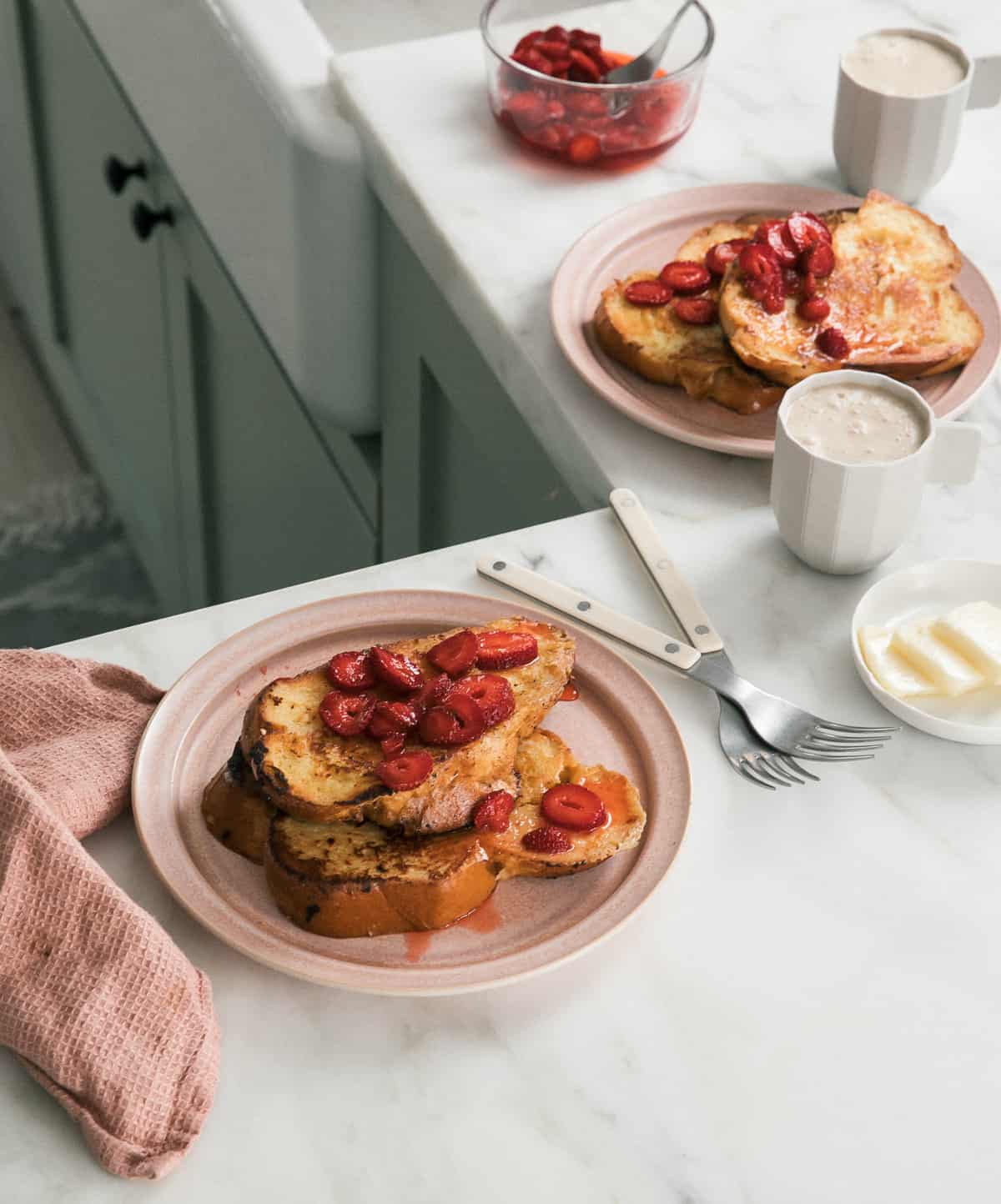 Custard French Toast with Macerated Strawberries on plates with coffee. 