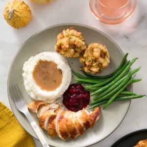 Stuffing muffins with glass of wine, green beans and cranberry sauce.