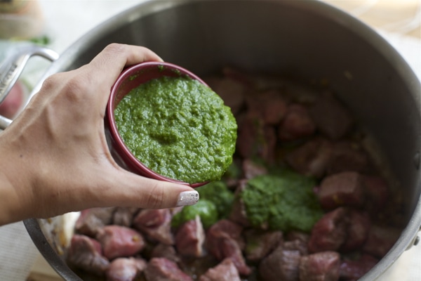 Cilantro marinade being added to the pot for Seco de Carne. 