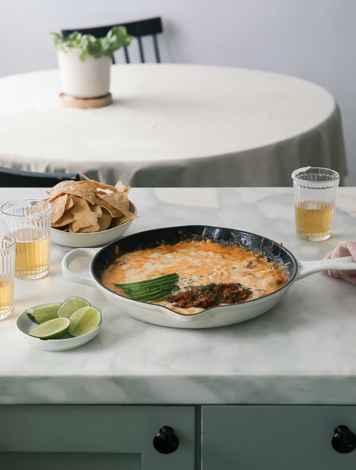 Skillet of queso fundido topped with chorizo and avocado.