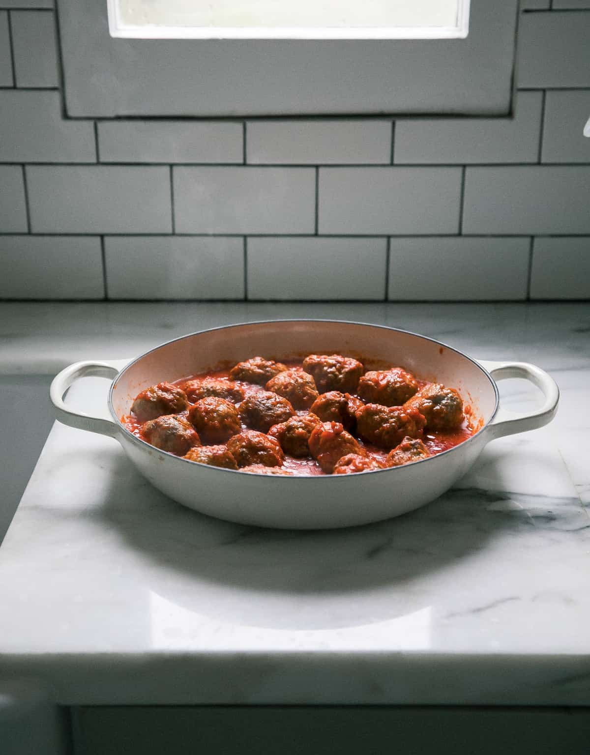 Meatballs in simmering sauce. 