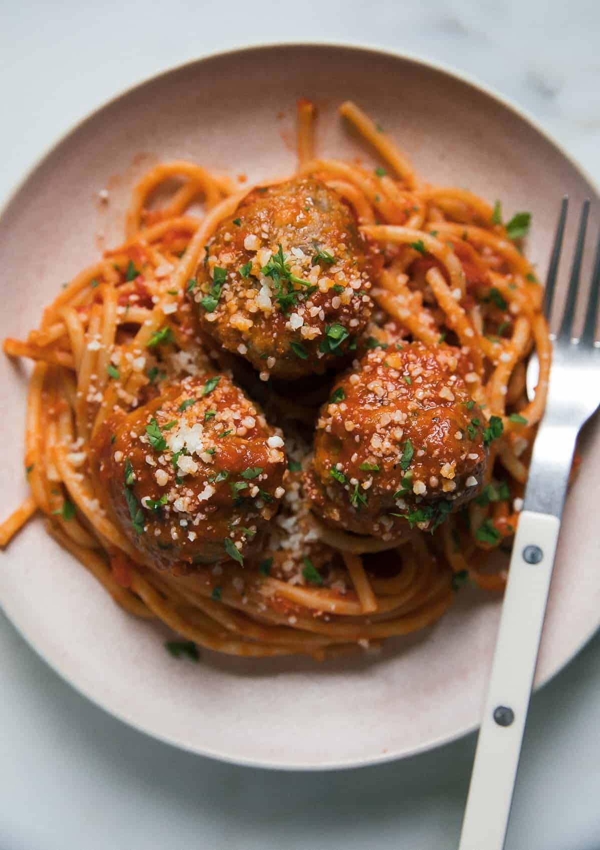 Spaghetti and Meatballs in a bowl with parmesan on top. 