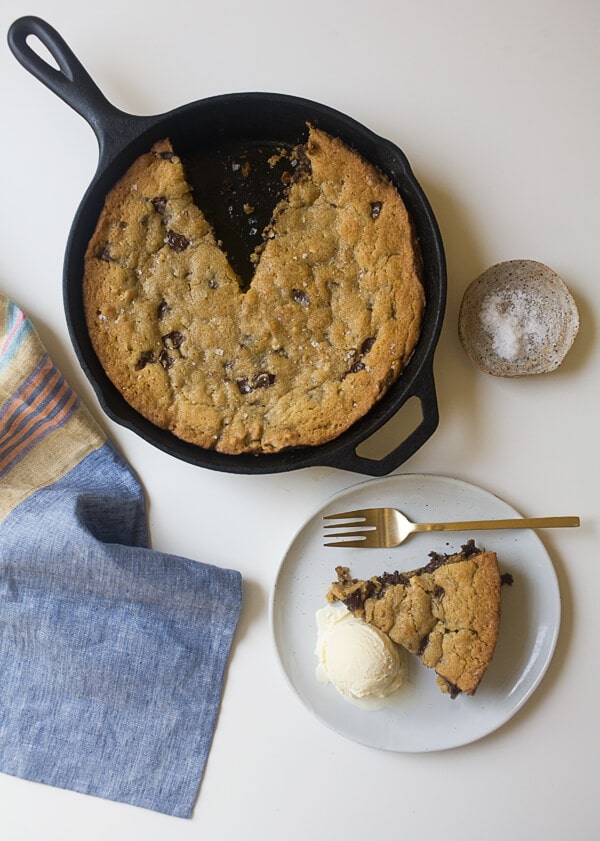 Chocolate Chip Skillet Cookie on a counter with a plate with the cookie. 