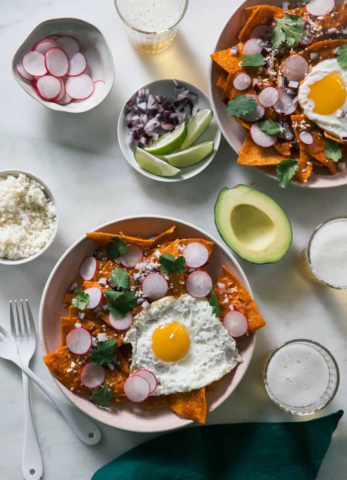 Two found blate of Chilaquiles with radishes, limes and avocado