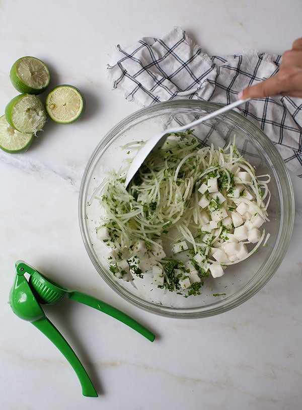 Jicama Slaw being mixed in bowl. 