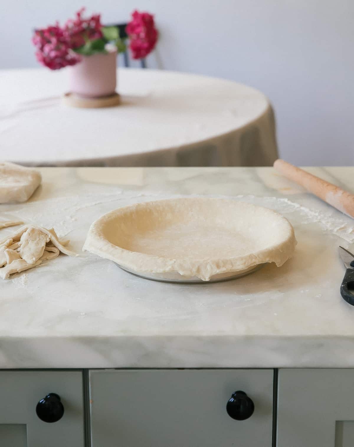 Unbaked pie crust in a pie pan on a counter.