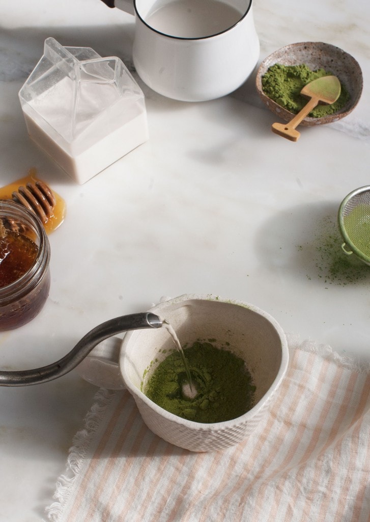 hot water going into mug with matcha 