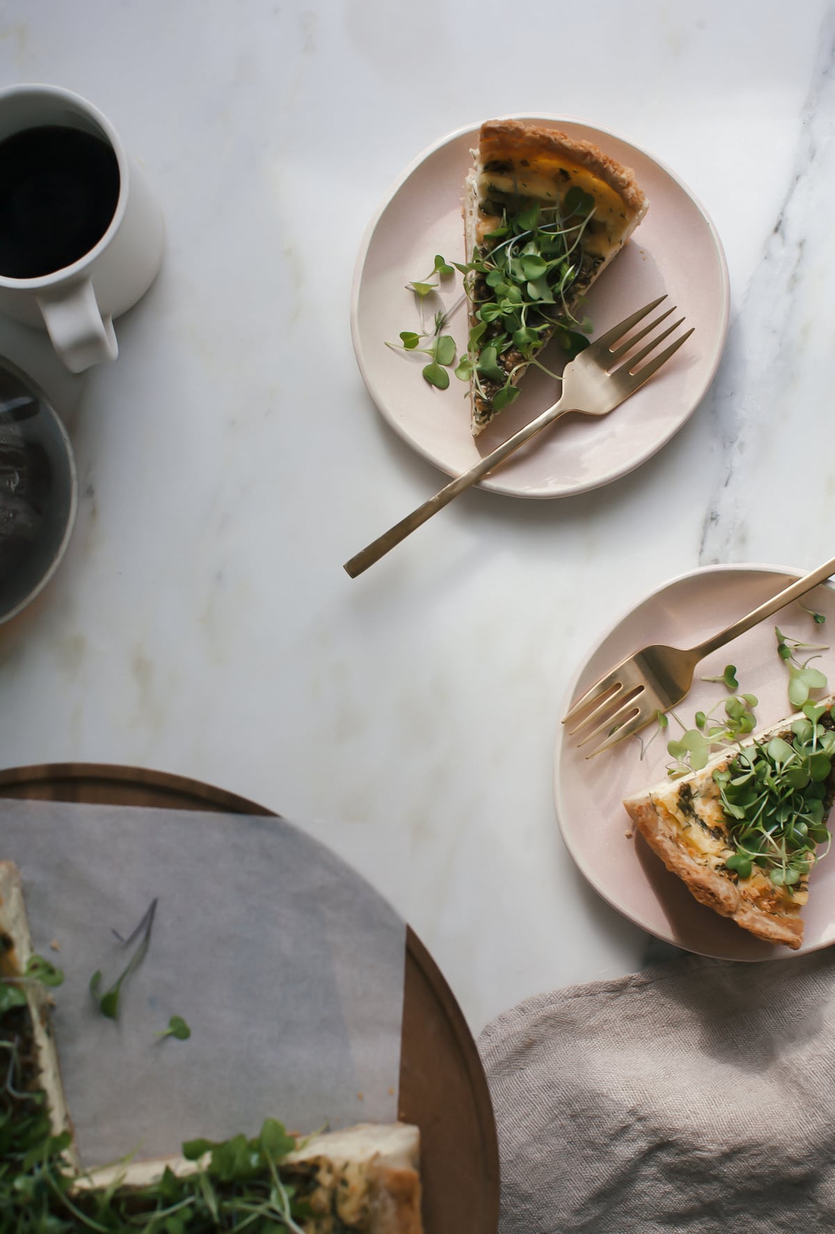 Quiche with Gruyére in slices on plates. 