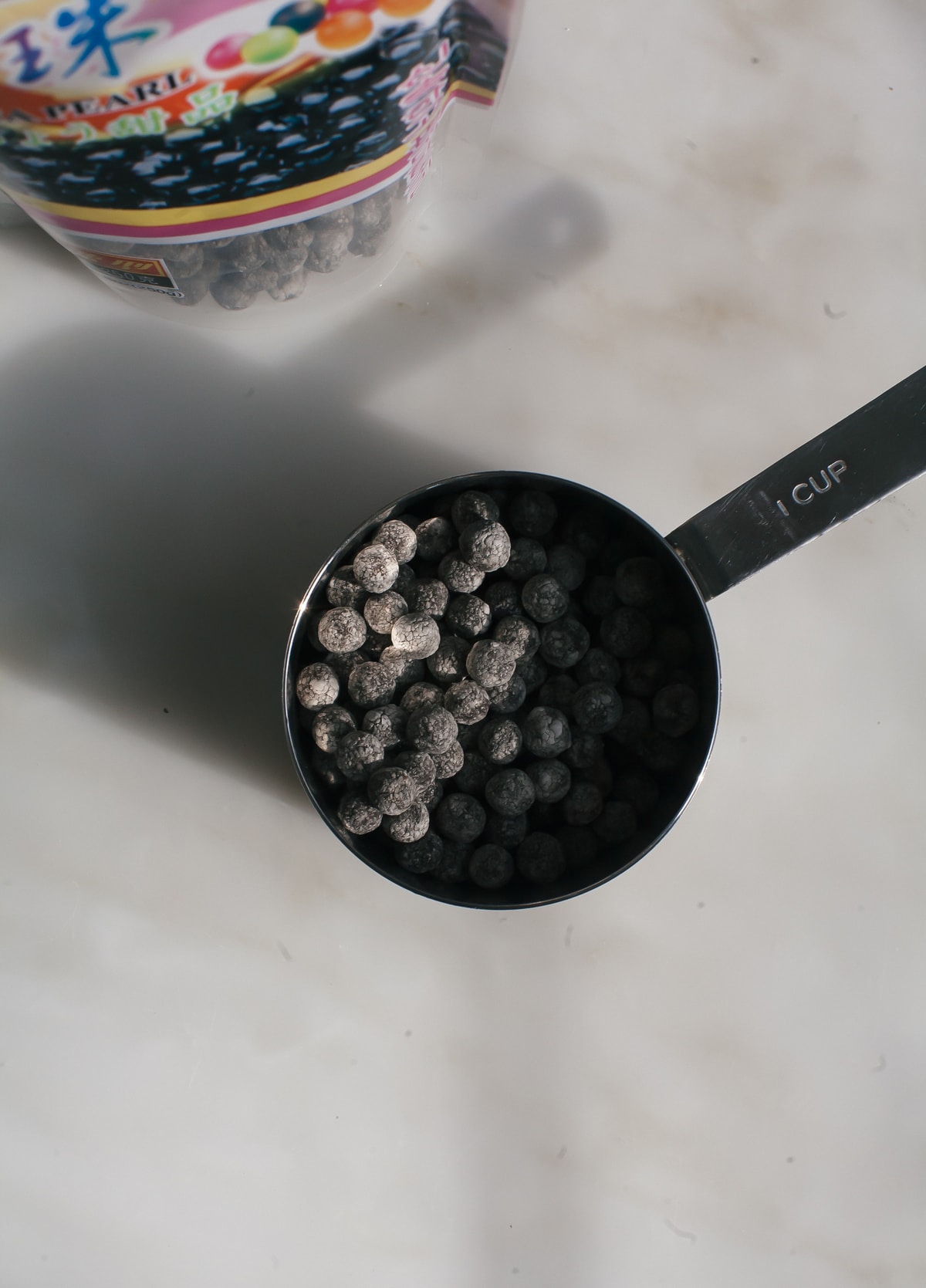 Black tapioca balls in a measuring cup.