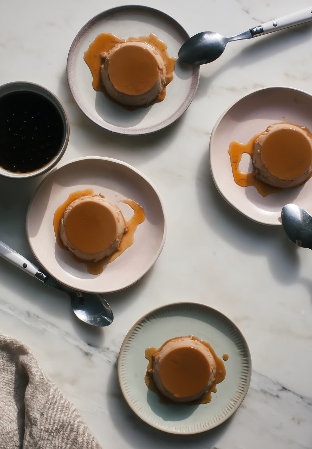 Overhead image of plates of flan with caramel sauce on top. 