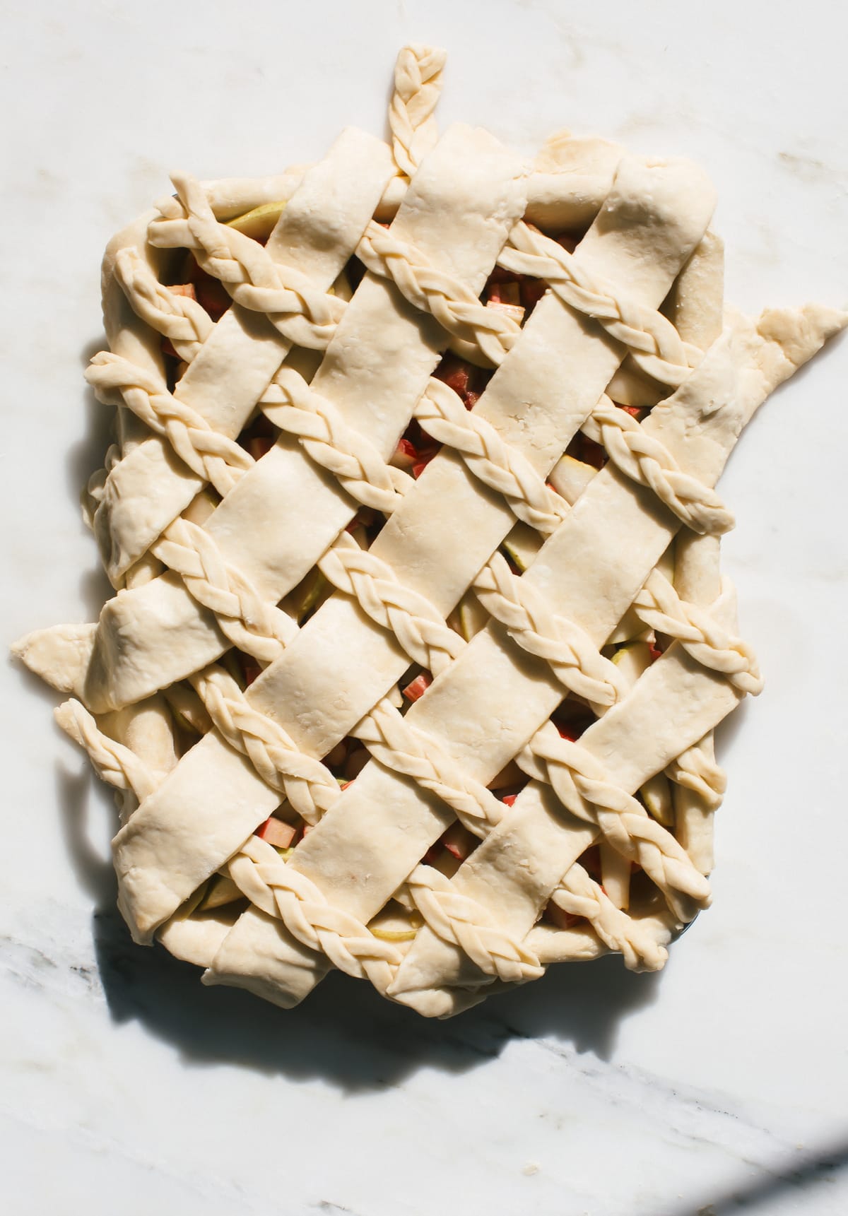 Overhead image of unbaked pie with lattice crust. 