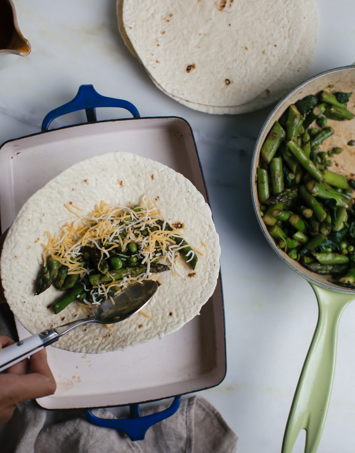 Veggie filling spooned on a tortilla with shredded cheese over top. 