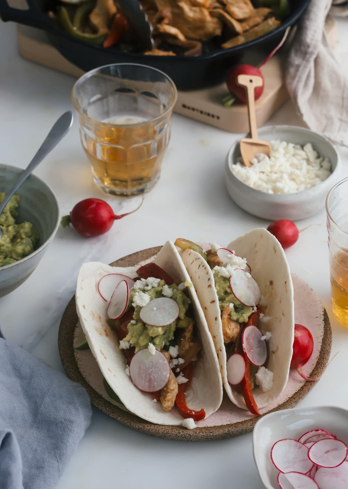 Close up image of chicken fajitas with toppings on a plate.