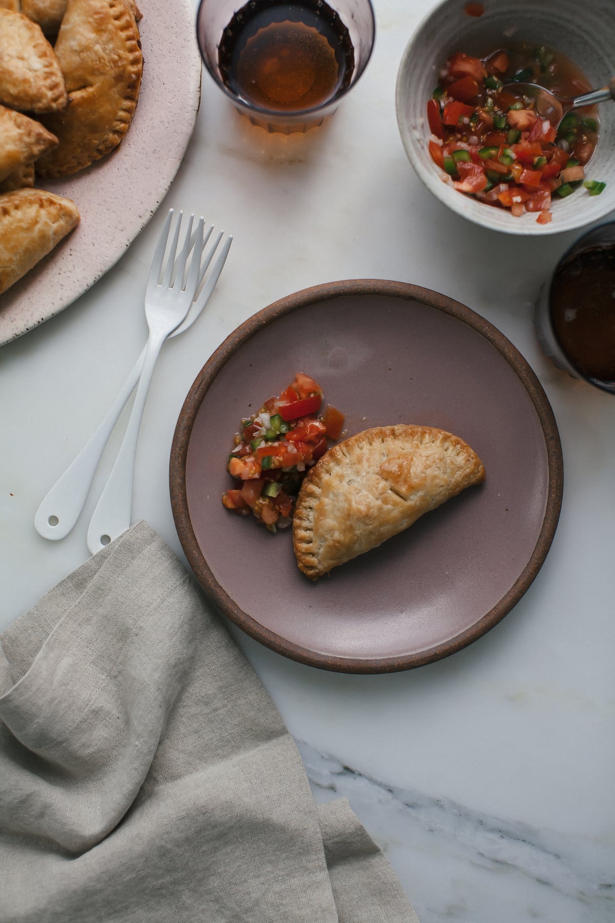Baked Beef Empanadas on a plate with salsa. 