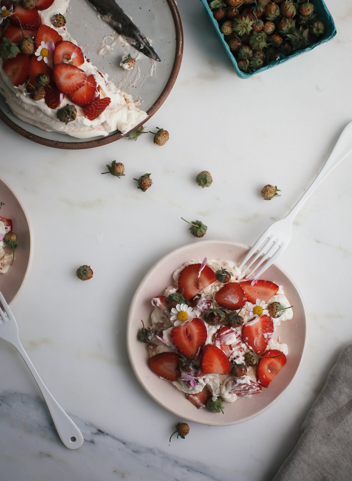 Meringue mixed with whipped cream and strawberries on a plate. 