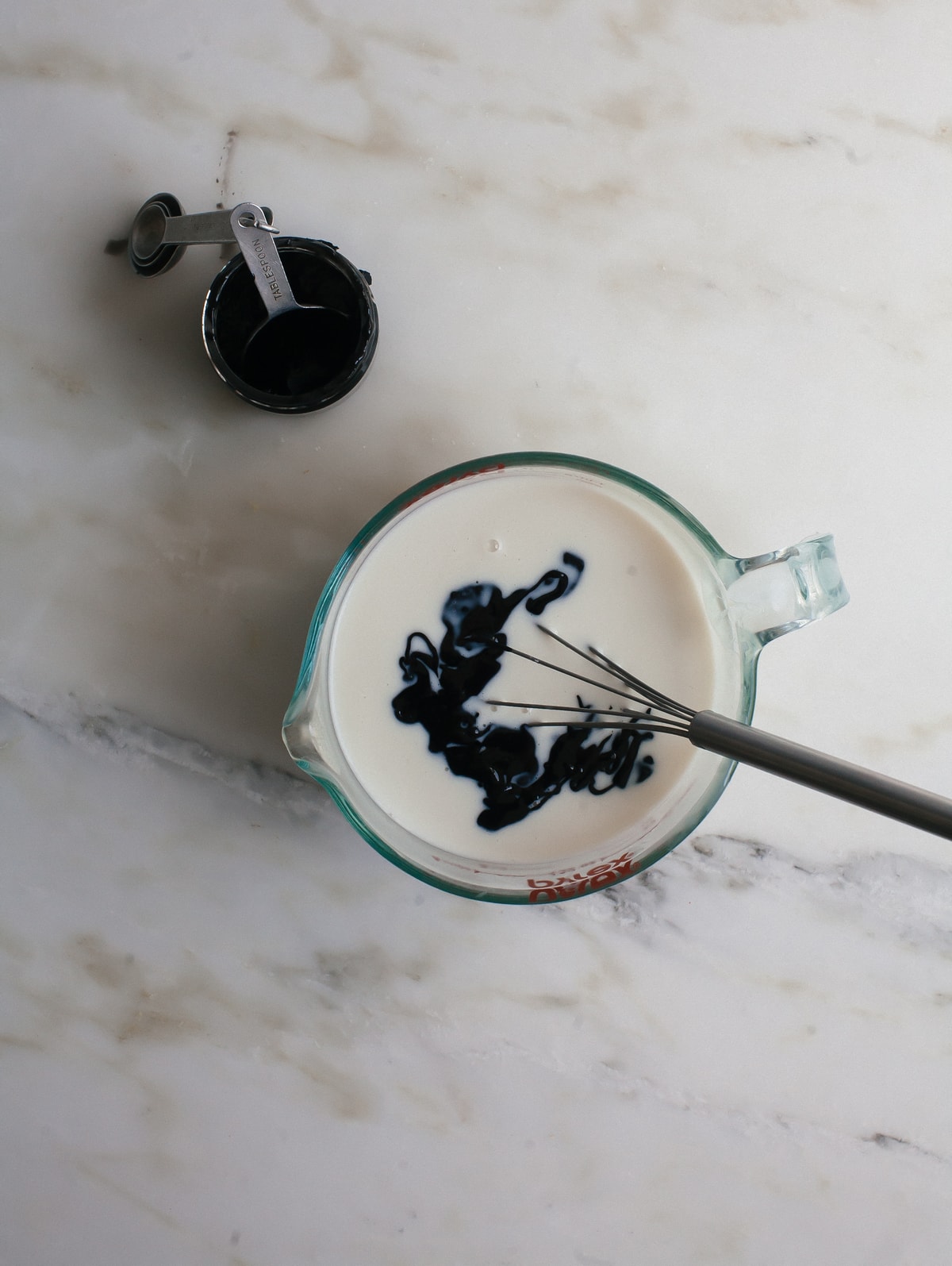 Popsicle ingredients in a measuring cup with a whisk.