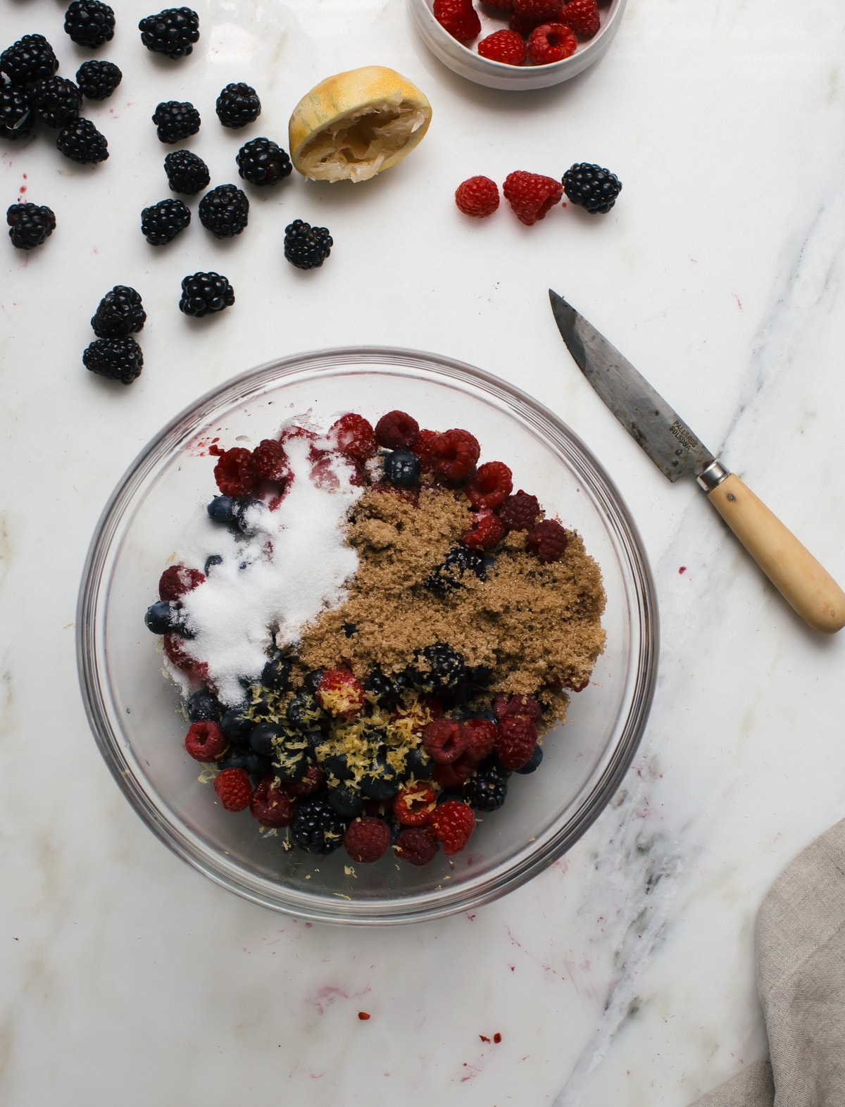 Fresh fruit in a bowl with sugar and lemon zest. 