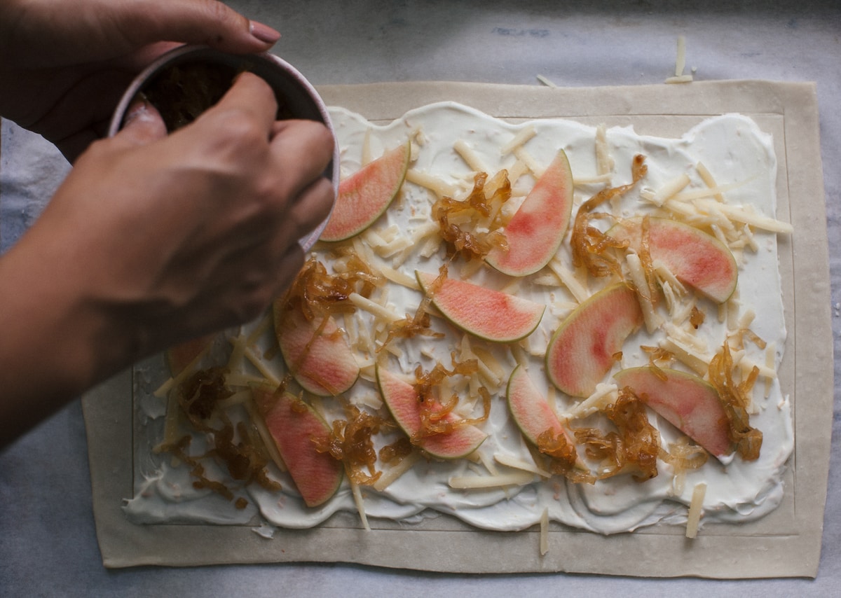 Apples and caramelized onions on top of tart. 