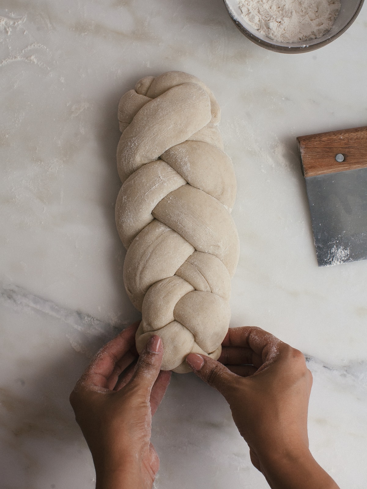 Tucking dough underneath the braid. 