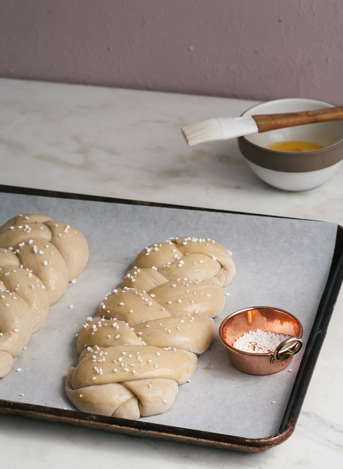 Swedish Cardamom Braided Bread on a baking sheet with pearl sugar. 