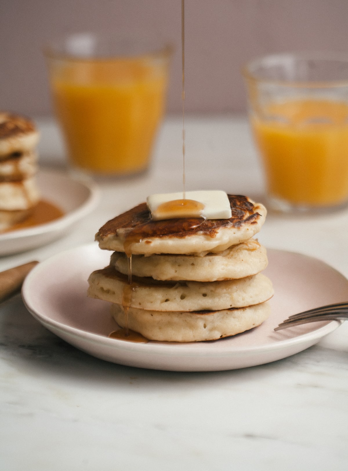 Pancake on a plate drizzled with maple syrup.