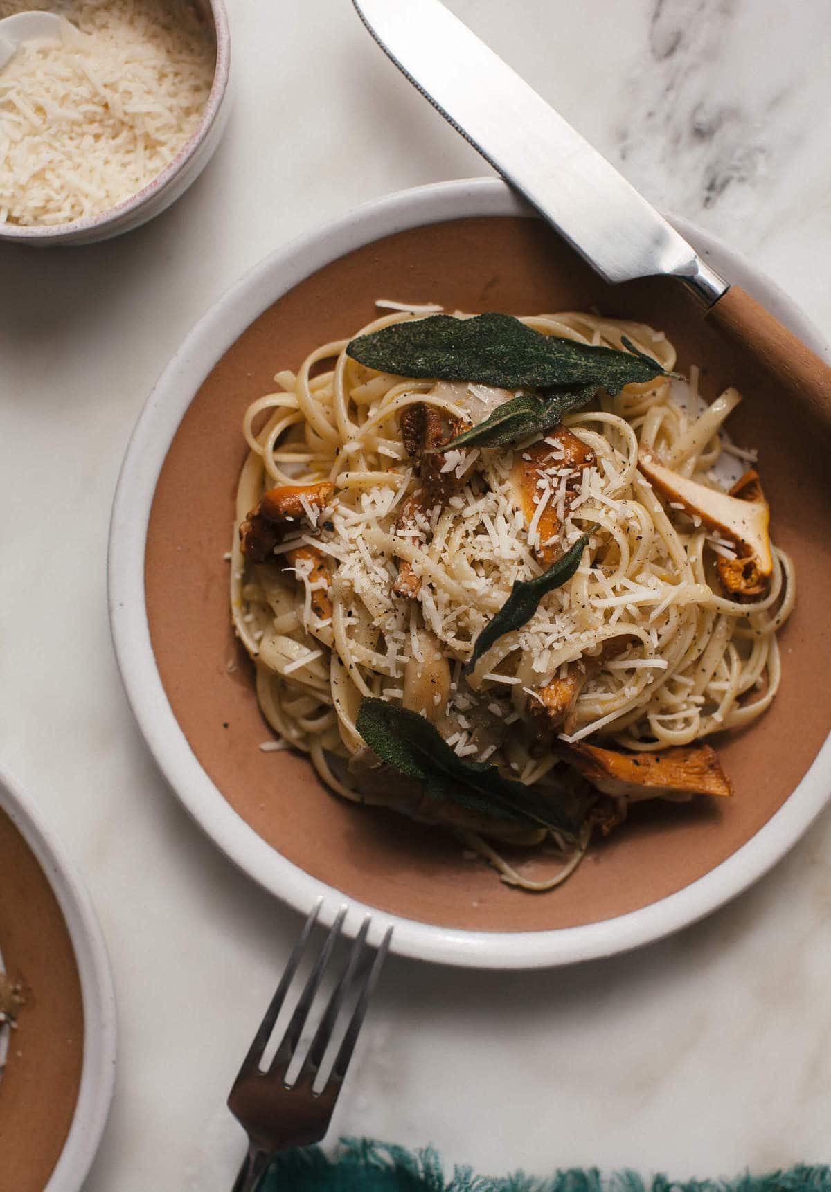 Wild Mushroom Spaghetti with Orange Brown Butter on a plate  topped with mushrooms and sage.