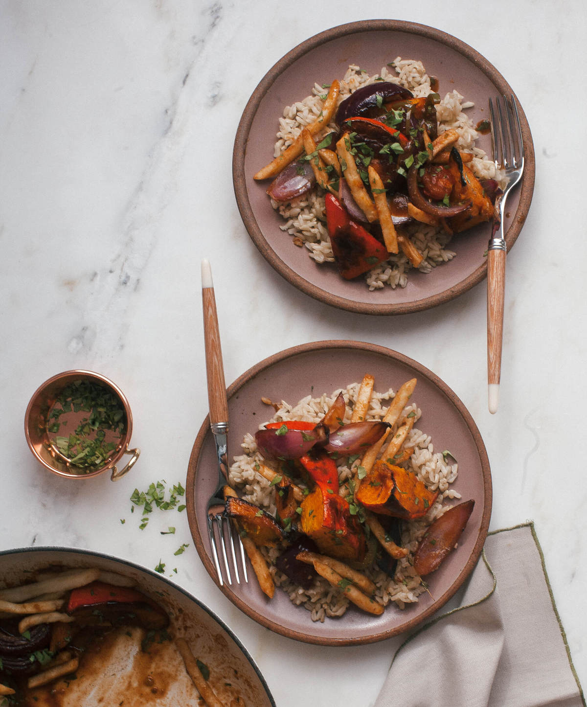 Squash saltado served over rice topped with fresh herbs. 