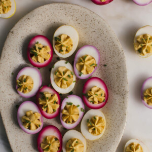 Naturally pickled deviled eggs on a platter topped with chives.