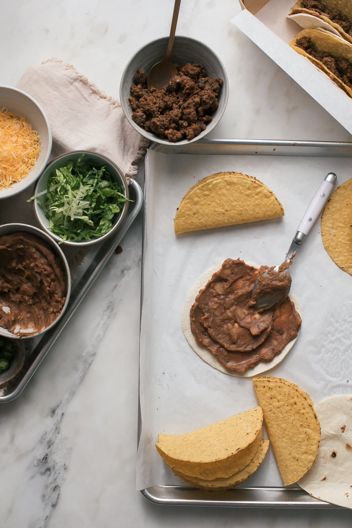 Refried beans spread over a tortilla completely.