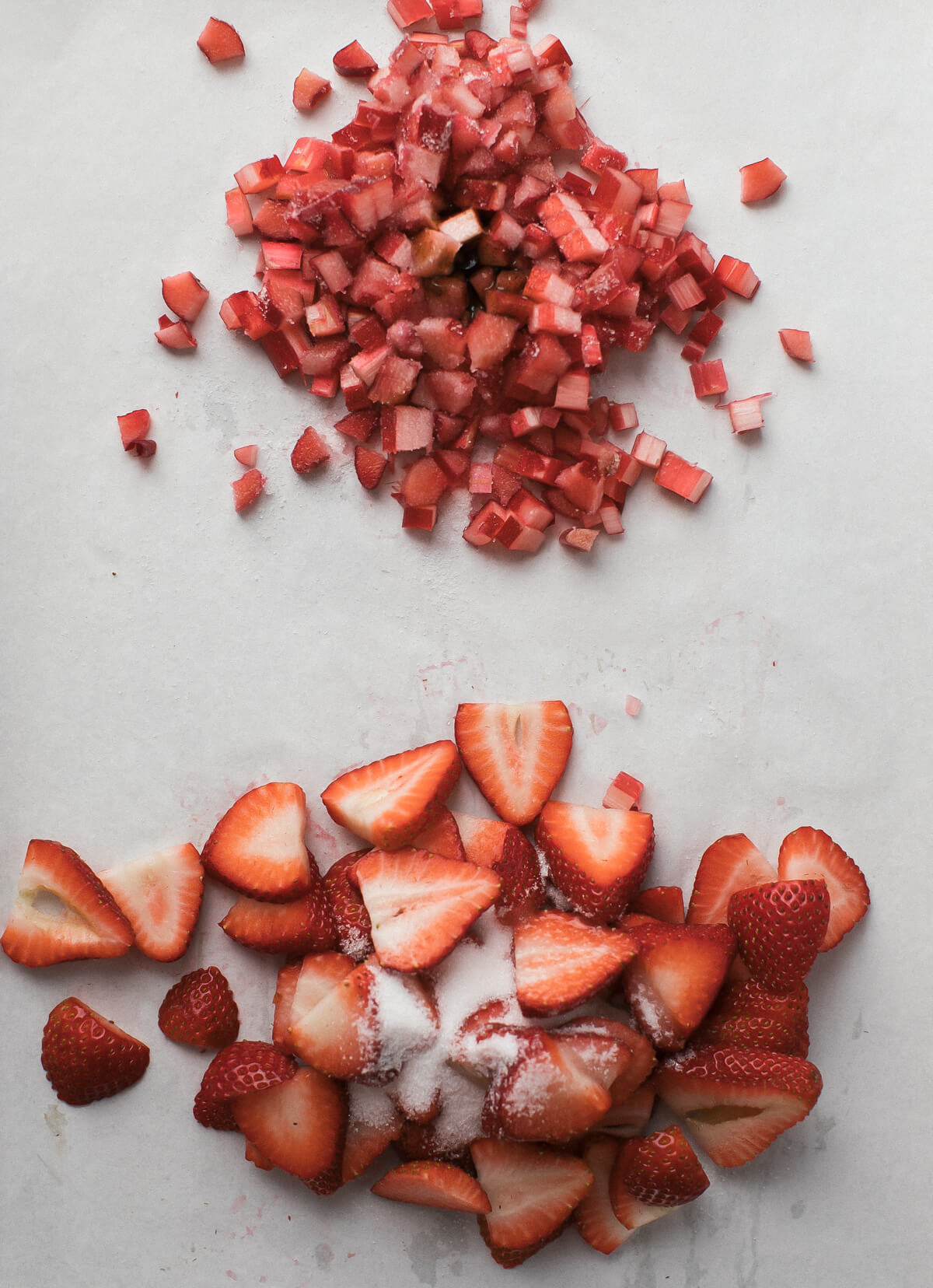Diced rhubarb and sliced strawberries on a counter. 