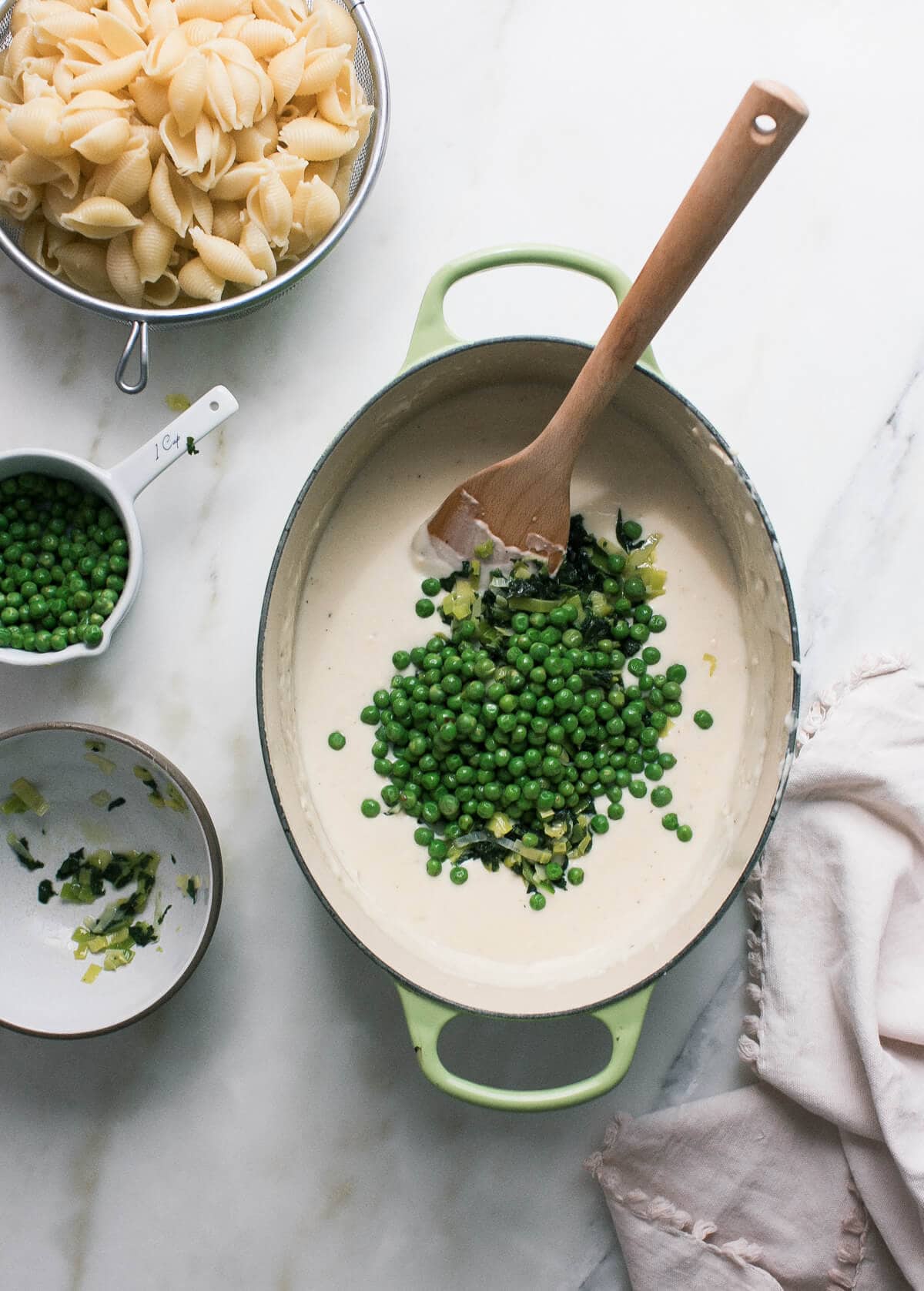 Cheese sauce in a pot with peas. 