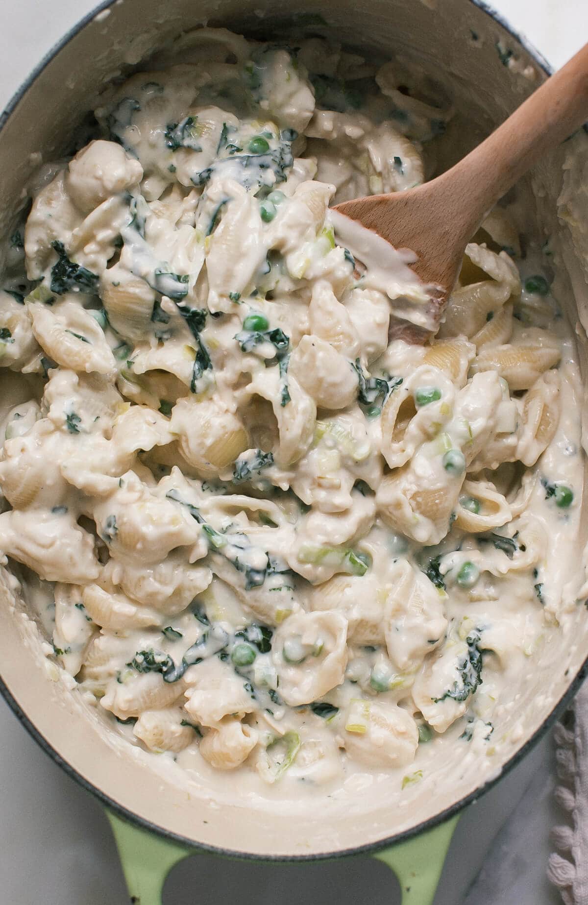 Close up image of stovetop macaroni and cheese in a pot with a spoon.