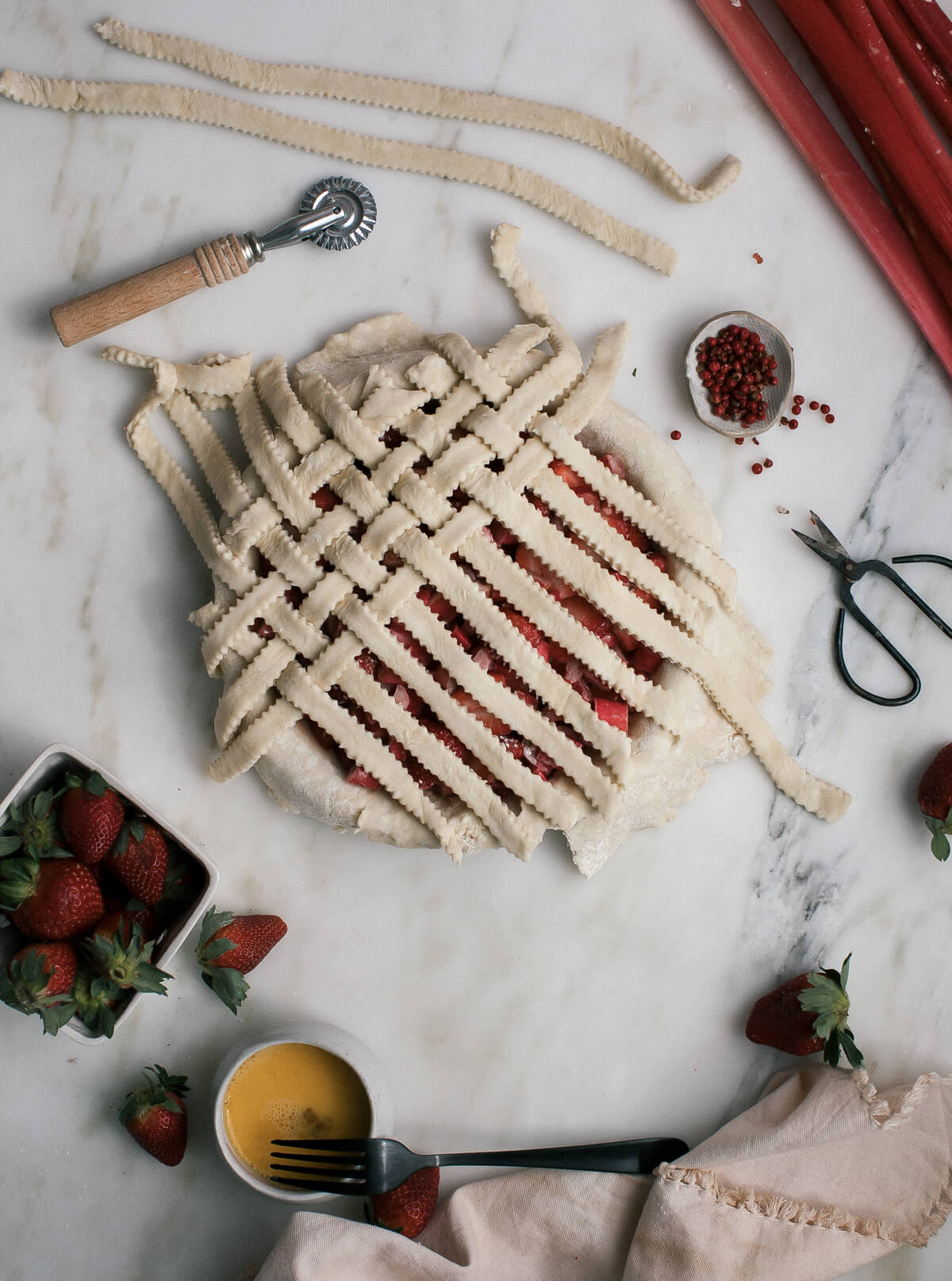 Process shot of an unbaked pie with a lattice crust.