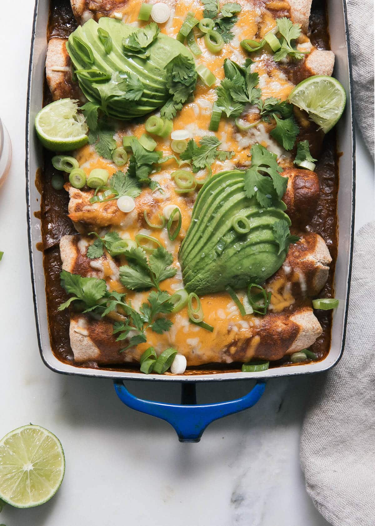 Close up of vegetarian black bean enchiladas in a baking dish.