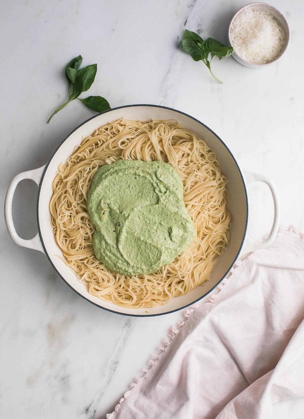 Pesto on top of cooked pasta in a dutch oven. 