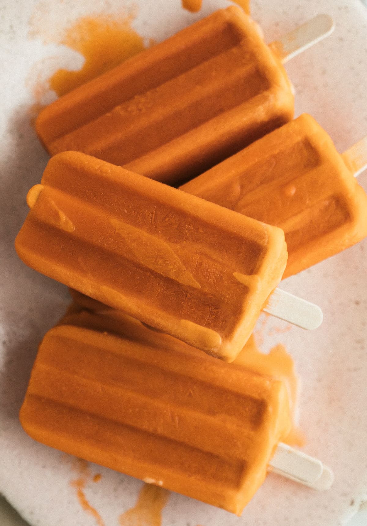 Overhead view of stacked popsicles on a plate.