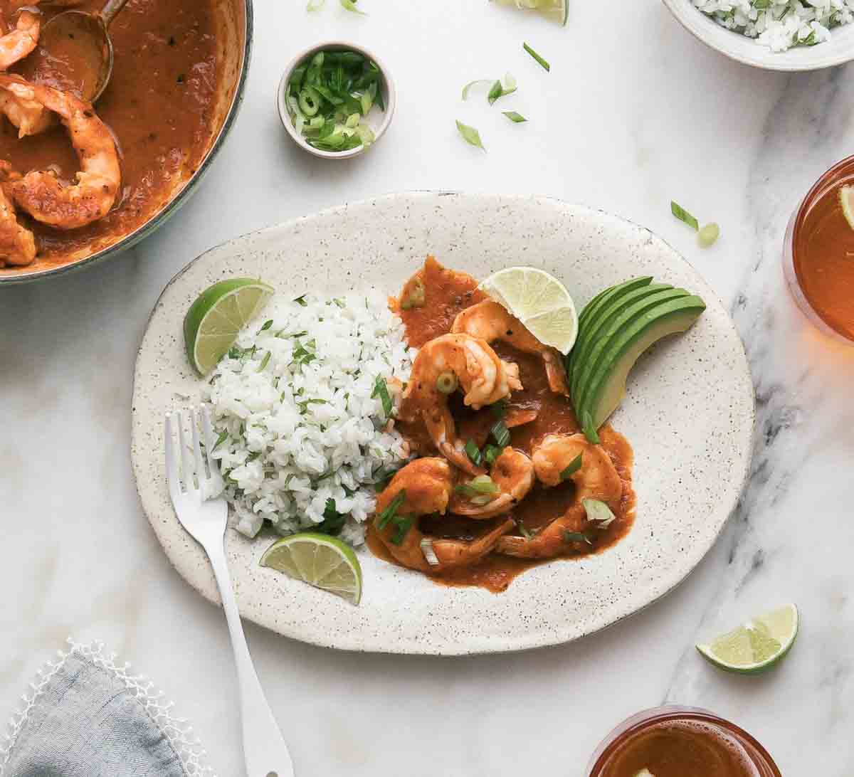 Camarones a la diabla on a plate with rice and avocado. 