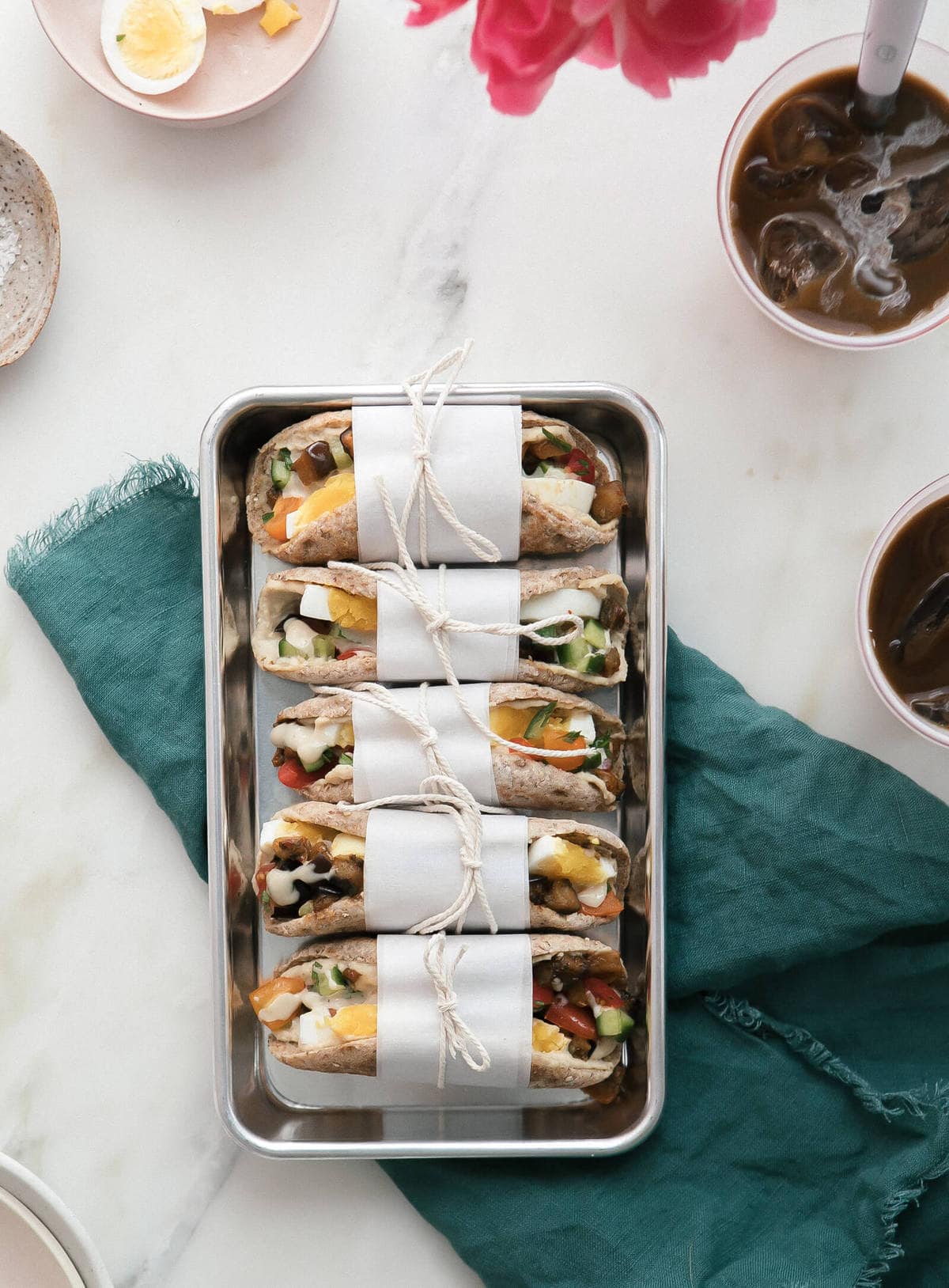 Overhead shot of sabich sandwiches on tray. 