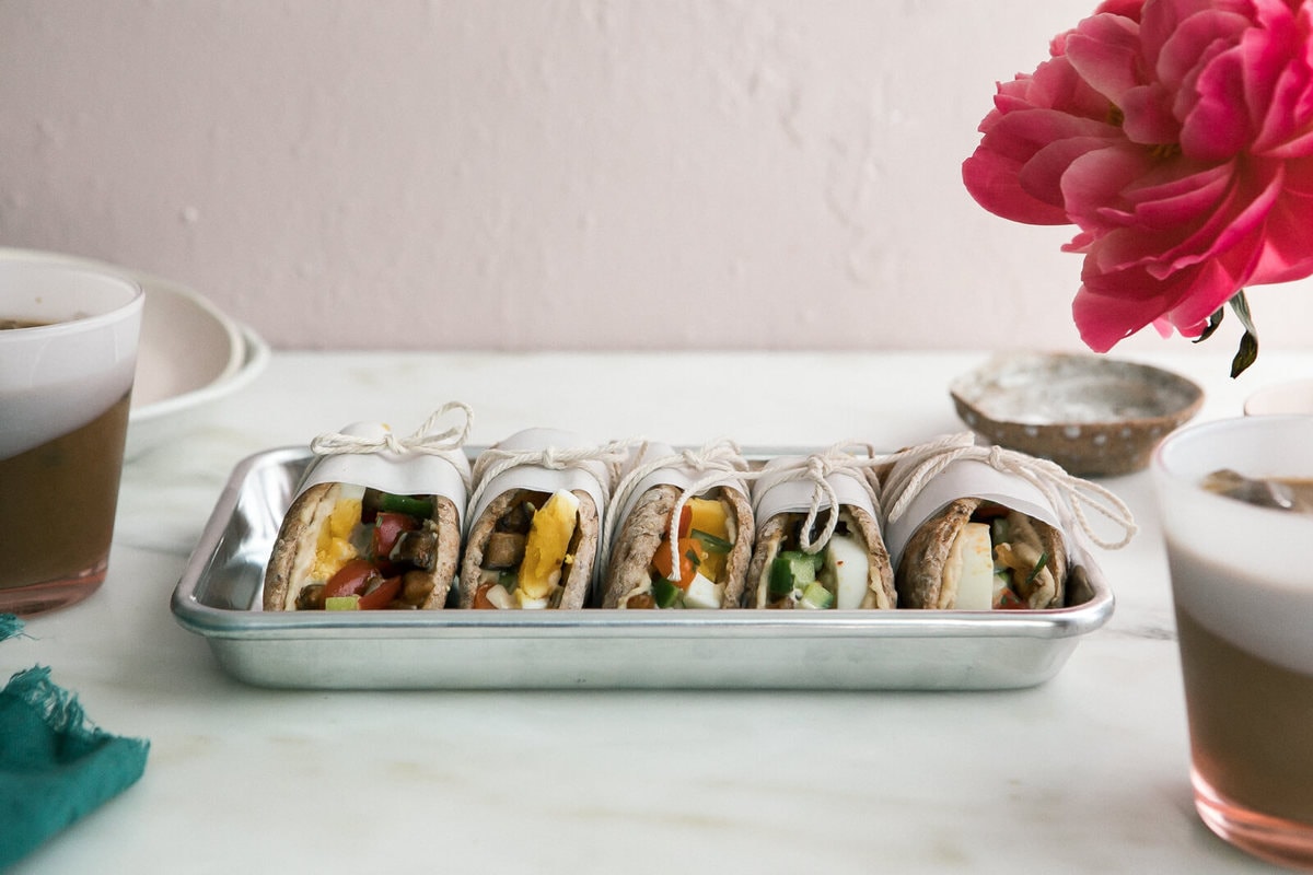 Sabich sandwiches on a tray with iced coffees. 