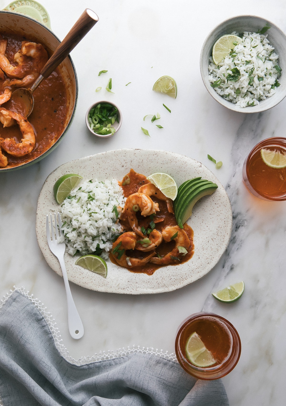 Overhead image of shrimp in red sauce on a plate with rice.