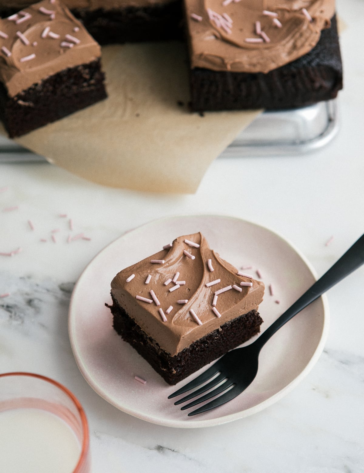 A slice of one bowl chocolate sheet cake on a plate with a fork. 