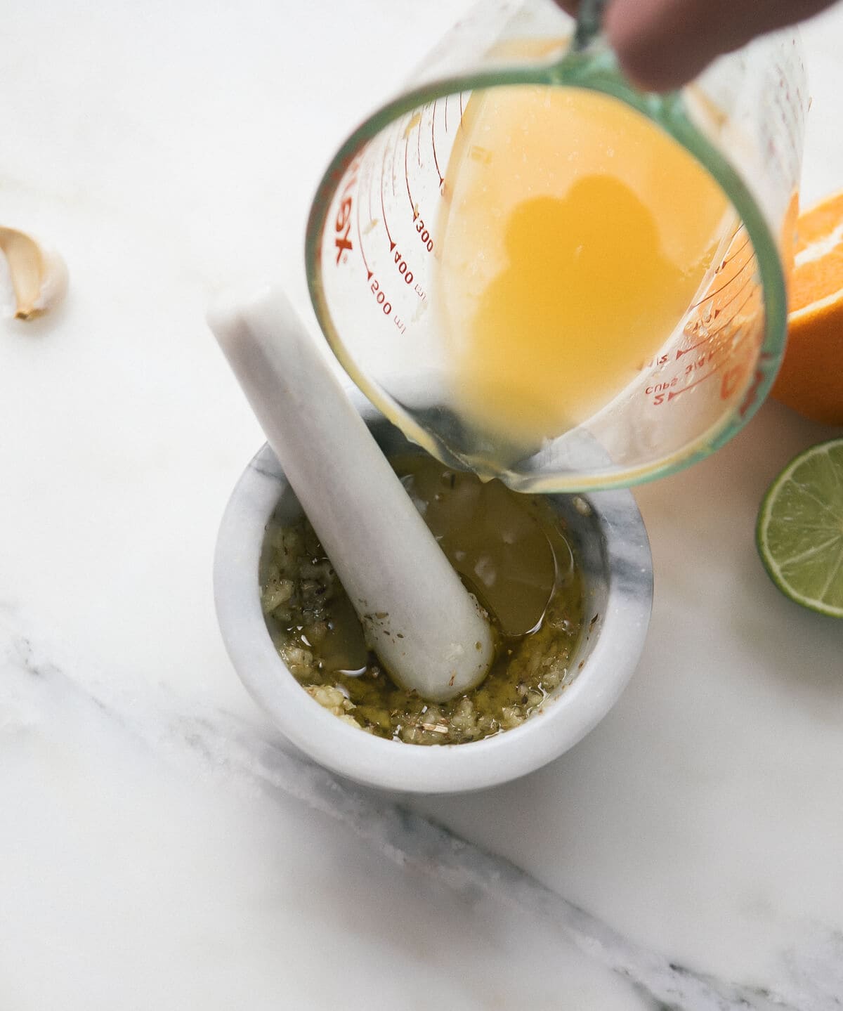 Citrus juices being poured into a mortar and pestle.