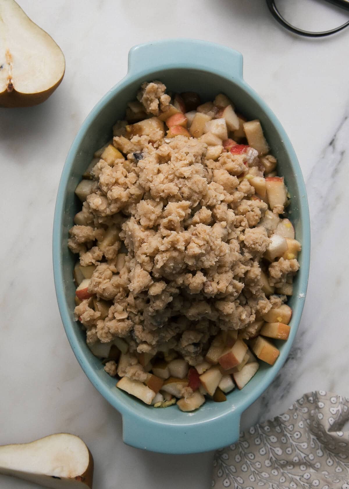 Fruit in a baking dish topped with oat topping.