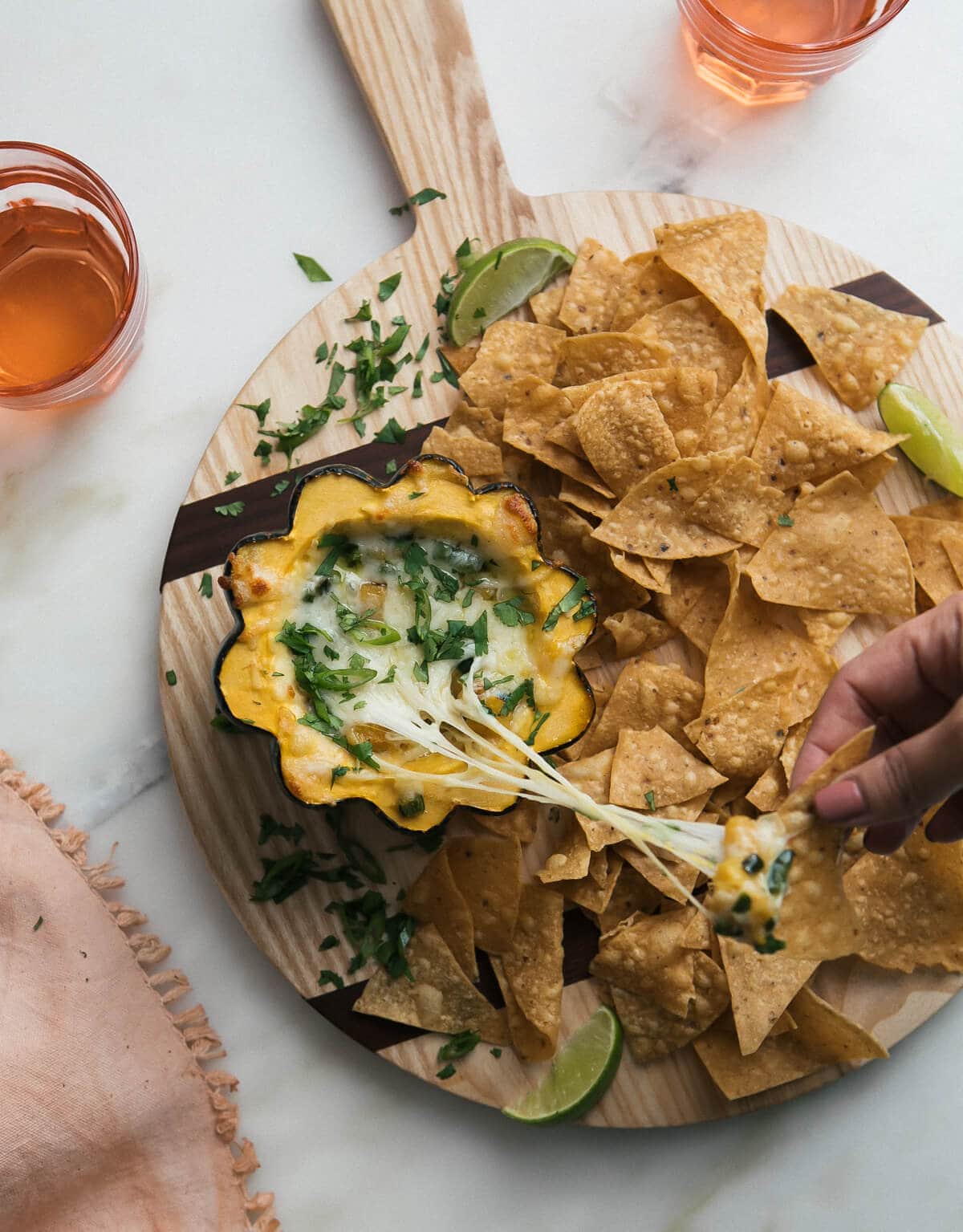 Overhead image of acorn squash pasilla chile queso fundido on a serving platter with tortilla chips. 