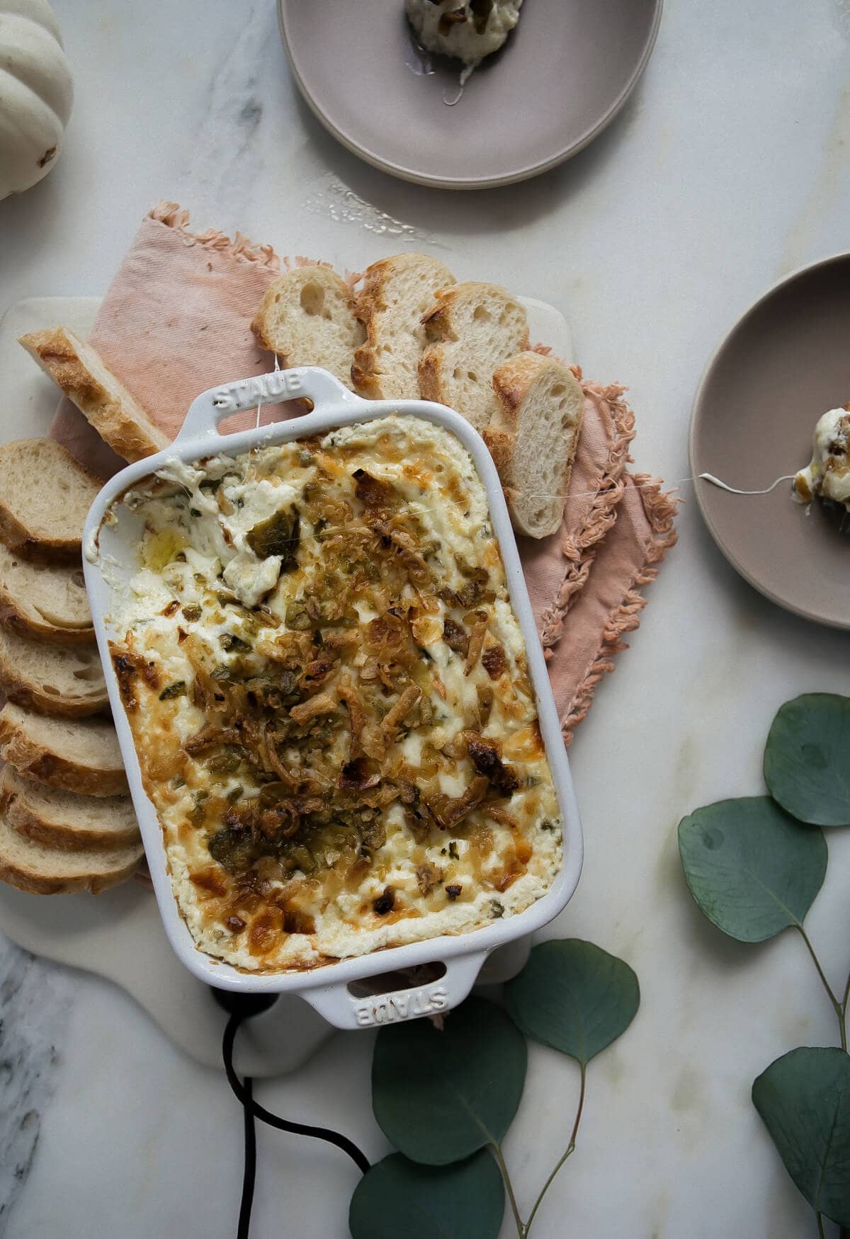 Jalapeño Popper Dip in a casserole dish with warm bread. 