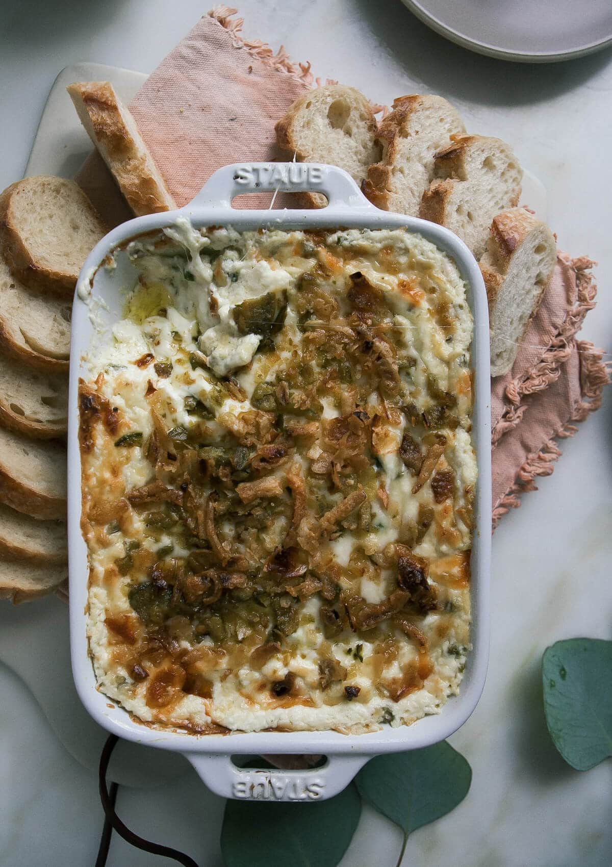 Jalapeño Popper Dip in a casserole dish with warm bread. 