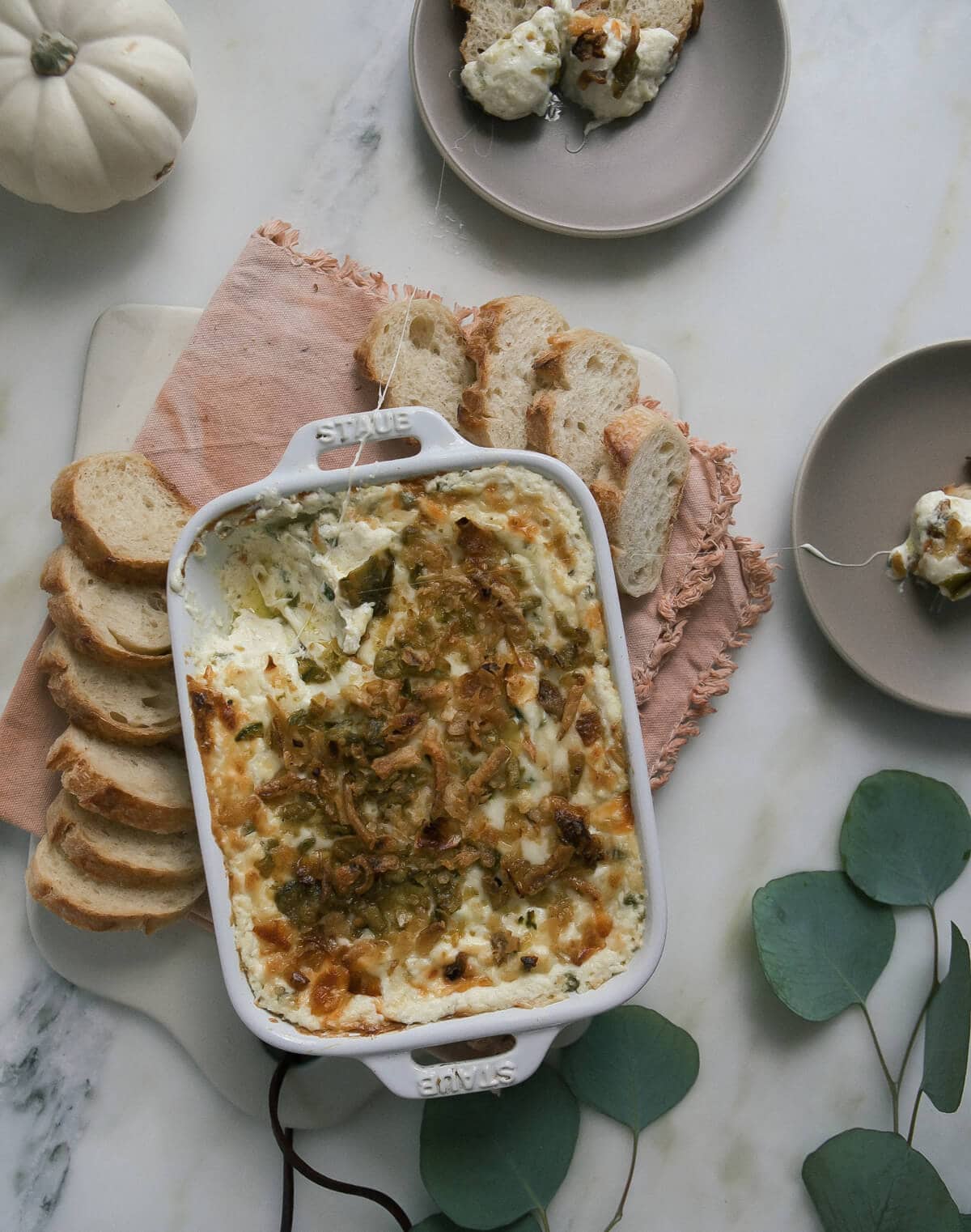 Jalapeño Popper Dip in a casserole dish with warm bread. 