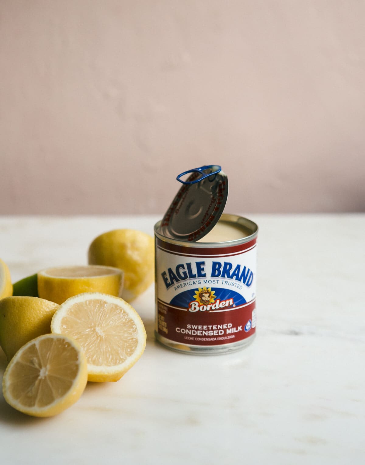 Side view of a can of sweetened condensed milk and lemons.